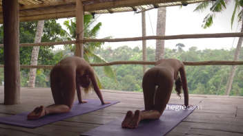 Two young naked women practice yoga in Bali